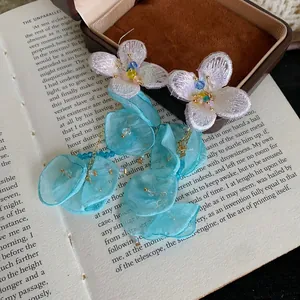 Detailed view of handmade blue chiffon flower tassel earrings with embroidered petals