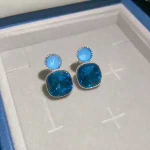 Fashionable square blue gemstone stud earrings featuring a stylish silver-tone setting