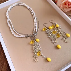 Multilayer pearl necklace and earring set featuring vibrant yellow resin lemon charms
