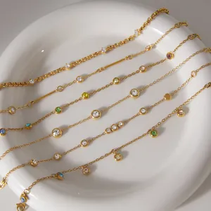 Macro-detail van verschillende vergulde roestvrijstalen armbanden met kleurrijke zirkoon