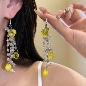 Elegant handmade long dangle earrings featuring resin lemon charms and white pearls.