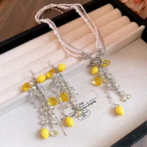 Elegant pearl beaded necklace and earring set featuring vibrant yellow resin lemon pendants