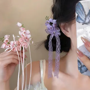 Detail of sweet chiffon flower hair clips with rhinestones and long lace tassels for women