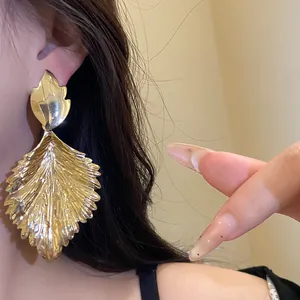 Macro detail of vintage gold-toned pleated leaf-shaped statement earrings