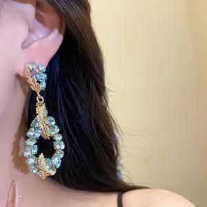 Detailed macro view of luxury light blue rhinestone feather teardrop earrings for women