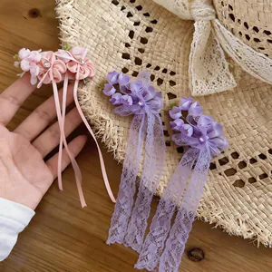 Detail of sweet chiffon flower hair clips with sparkling rhinestones and lace tassels.