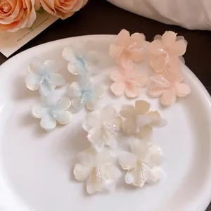 Elegant fabric flower earrings in pastel shades perfect for seaside vacation outfits.