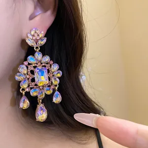 Close-up of vintage iridescent flower drop earrings with shimmering crystals.