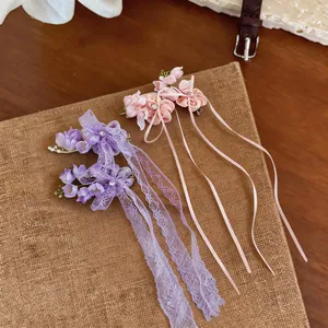 Detail view of purple and pink chiffon flower hair clips with lace and satin ribbons