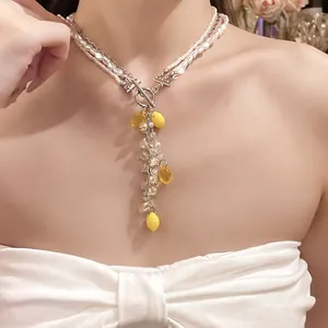 Close-up of elegant pearl necklace with yellow resin lemon charms and silver OT clasp