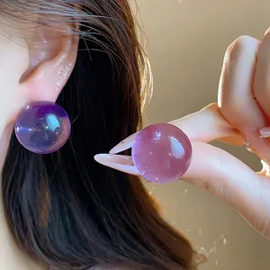 Dettaglio orecchini a lobo a sfera in resina viola trasparente per stile elegante