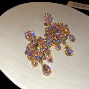 Detail view of vintage iridescent crystal flower teardrop earrings on a shell plate.