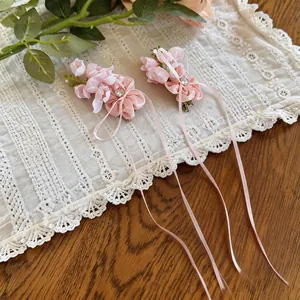 Detailed view of pink chiffon flower hair clips with long ribbon tassels and rhinestones