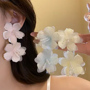 Detailed view of handmade pastel mesh flower earrings with delicate beaded centers