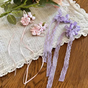 Detail shot of chiffon flower hair clips with rhinestones and elegant lace tassels.