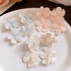 Detailed view of pastel organza flower earrings with delicate crystal bead centers.