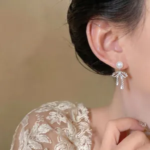 Elegant French style silver bow earrings with pearl stud for a minimalist look