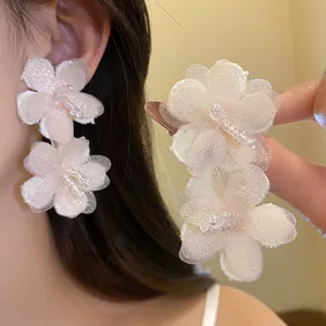 Close-up of elegant pink mesh flower earrings with delicate crystal bead centers