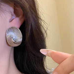 Detailed macro shot of an elegant silver oval textured earring with a central pearl