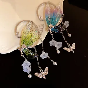Macro view of fairy wing earrings with iridescent resin wings and flower charms