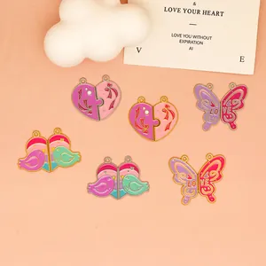 Close-up of colorful enamel heart, butterfly, and bird jewelry charms for DIY necklaces.