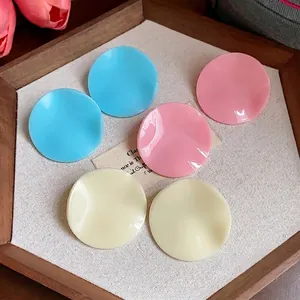 Stylish minimalist acrylic round pleated stud earrings in blue, pink, and cream colors.