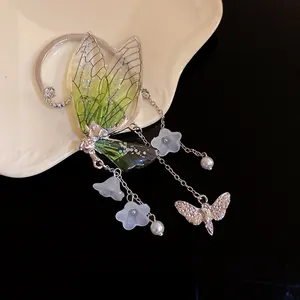Close-up of forest style resin wing earrings with frosted blue flowers and pearls