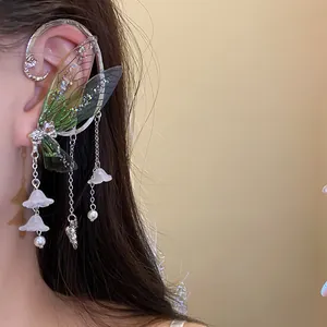 Detailed view of forest style resin butterfly wing earrings with floral tassels