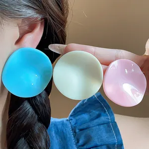 Close-up of pleated acrylic round stud earrings showing vibrant blue and soft pink colors
