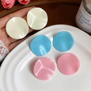 Detail view of stylish round pleated acrylic earrings in multiple soft pastel colors