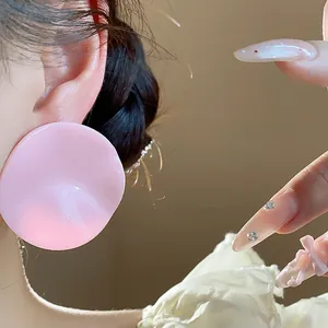 Close-up view of elegant pink acrylic pleated round stud earrings on ear for women