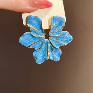 Macro detail of elegant blue flower-shaped alloy stud earrings with sparkly finish