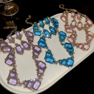 Macro view of vintage geometric square gemstone necklaces in vibrant purple, blue and pink.