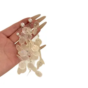 Boucles d'oreilles pendantes vintage avec coquillages blancs et perles sur blanc