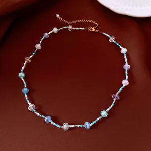 Gros plan d'un collier en perles de verre colorées sur un fond marron soyeux