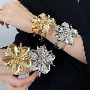 Detailed view of the oversized metallic gold and silver flower open cuff bracelets