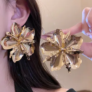Detailed view of oversized vintage gold flower earrings with polished metallic finish