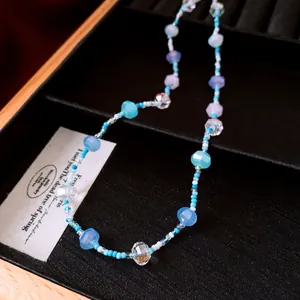 Vue détaillée du collier de perles en verre bleu et violet dans une boîte