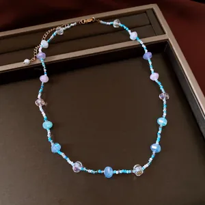 Détail d'un collier de perles en verre colorées disposé dans un plateau à bijoux