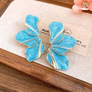 Close-up detail of vintage blue enamel flower petal earrings with gold-plated edges