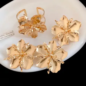 Detail view of vintage gold metallic flower jewelry set including ring and stud earrings