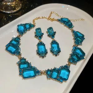 Detailed view of a vintage palace style necklace and earrings with blue square gems
