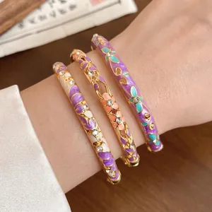 Set of three vintage floral enamel bangles with sparkling rhinestones and gold finish.