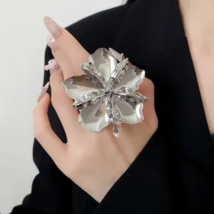 Detailed view of an oversized silver metal flower open ring with high-gloss finish