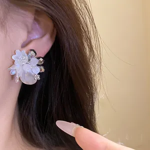 Dettaglio ravvicinato che mostra la trama di eleganti orecchini a fiore in cristallo bianco