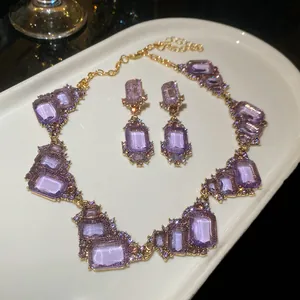 Vintage palace style necklace and earrings set with purple square gemstones on gold.