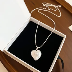 Close-up of heart-shaped pearl pendant necklace displayed in elegant jewelry box
