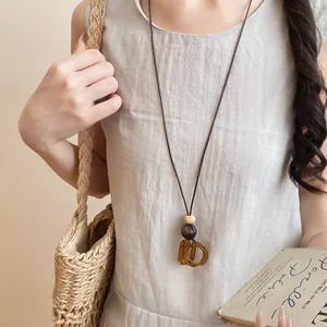 Detailed view of brown resin geometric pendant on long leather cord necklace