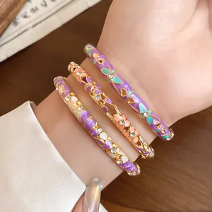 Detail shot of vintage style enamel flower bangles decorated with shimmering rhinestones.