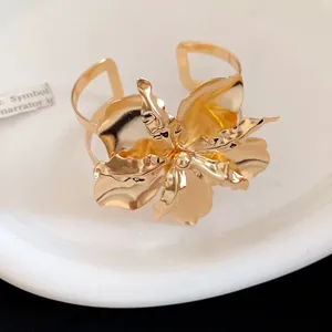 Detailed view of polished gold metal floral open cuff bracelet